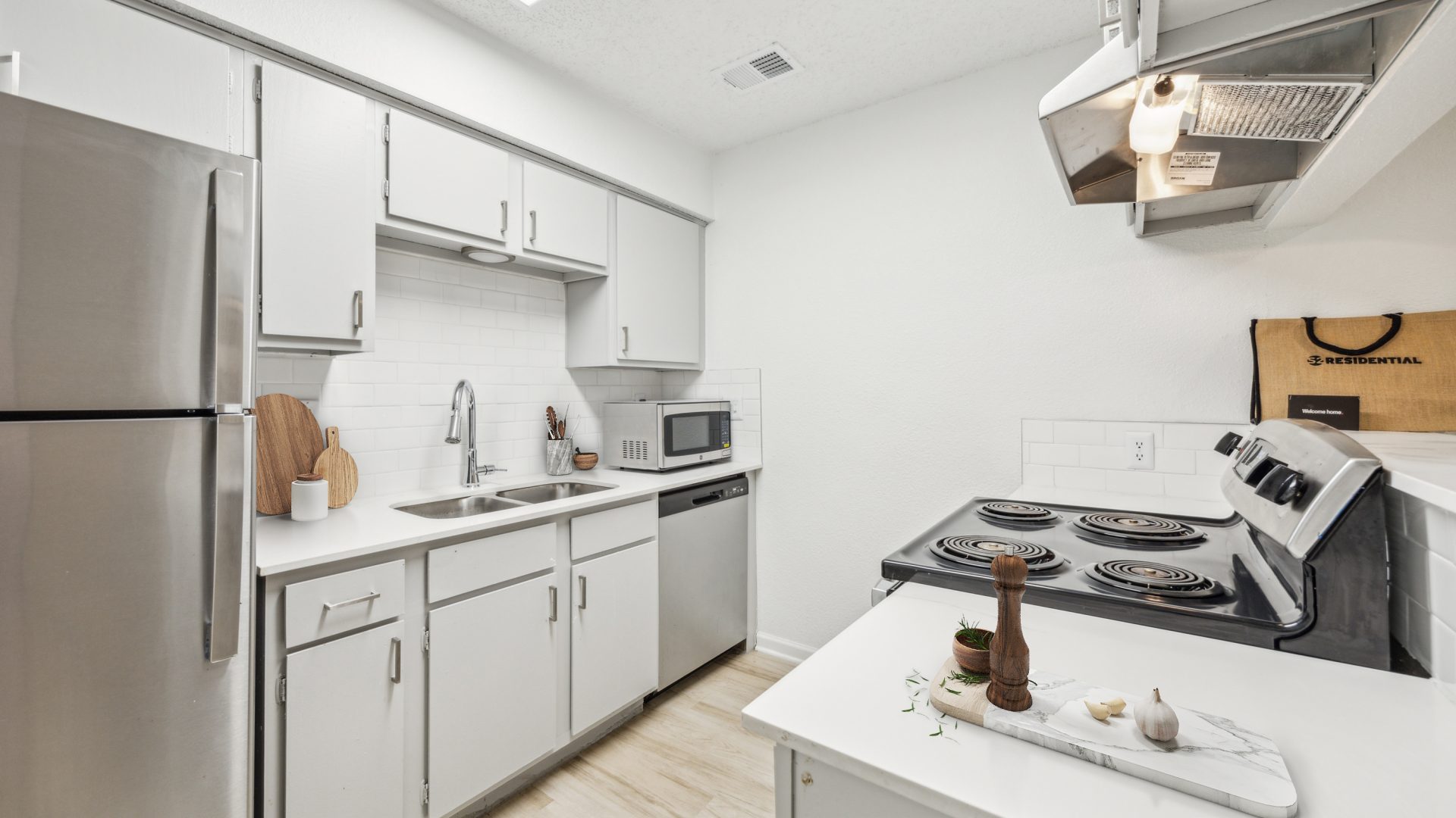 a kitchen with stainless steel appliances and white cabinets at The Falltree Apartments